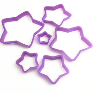Macro detail of six purple star-shaped plastic cookie cutters in various sizes
