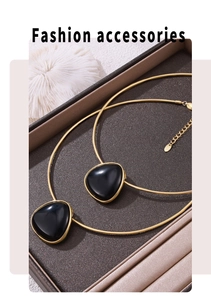 Detail of gold snake chain necklaces with triangle black onyx pendants in a luxury gift box