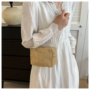 Detail of a natural straw woven crossbody bag with a slim strap for a casual summer style