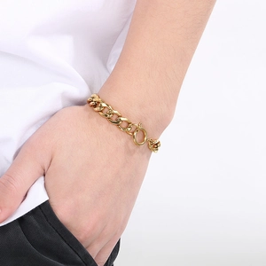 Close-up of a gold Cuban link chain bracelet on wrist with a minimalist spring clasp
