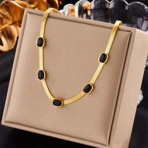 Elegant gold snake chain necklace featuring five rectangular black gemstones on a display box