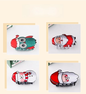 Detail shot of four Christmas themed hair claws featuring Santa and snowman patterns