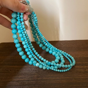 Detail of multi-layered turquoise beaded necklace with adjustable metal chain and lobster clasp