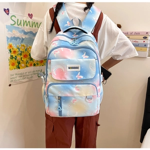 Detail of blue-pink gradient backpack featuring butterfly prints and a fashion label