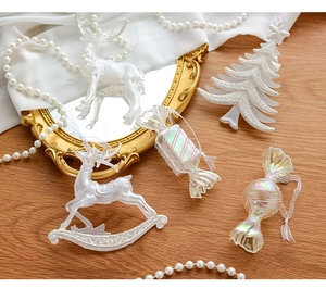 Elegant pearlescent white Christmas ornaments with reindeer and tree shapes on wood