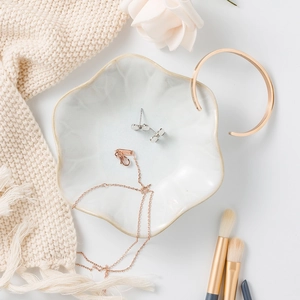 Irregular light blue ceramic jewelry dish with elegant rose gold necklace and bracelet