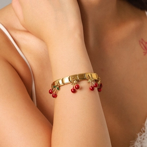 Italian modular elastic bracelet in gold stainless steel with red cherry charms on wrist