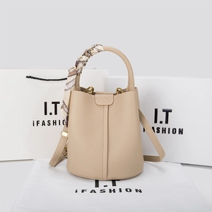 Close-up of beige lychee grain leather bucket bag with silk scarf handle detail