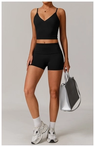Detail shot of women's black high-waisted fitness shorts and V-neck sports camisole