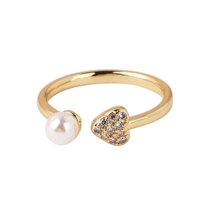 Macro view of gold heart ring featuring micro-pave zircon crystals and a round pearl