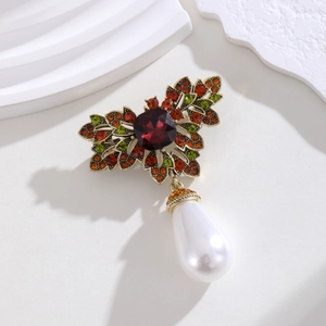 Macro detail of French vintage gold brooch with colorful crystals and a teardrop pearl