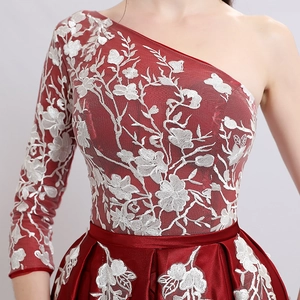 Elegant one-shoulder wine red evening gown with white floral embroidery and satin skirt