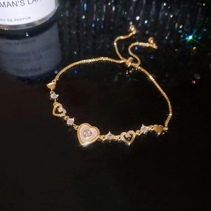Detailed macro view of gold-plated adjustable heart bracelet with zircon stones