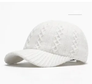 Close-up of off white cable knit baseball cap showing detailed winter texture
