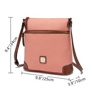 Detailed size view of pink pebbled leather crossbody bag with brown trim and gold hardware