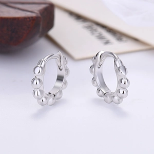 Macro shot of silver beaded hoop earrings featuring a minimalist sphere link design