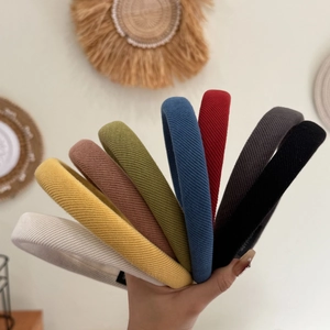 Détail de serre-têtes en tricot côtelé coloré tenus à la main en divers tons chauds