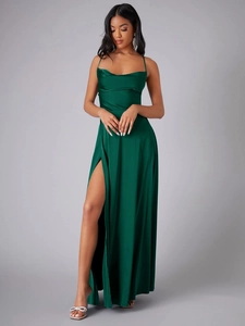 Détail de la robe de soirée en satin vert foncé avec fente latérale haute et texture soyeuse