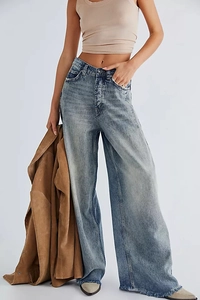 Détail de jean taille haute à jambe large avec délavage bleu et ourlet effiloché vieilli