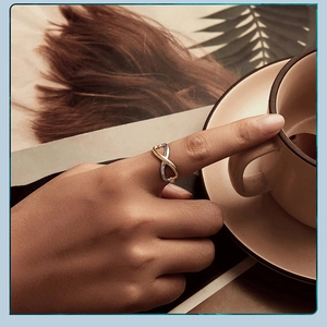 Artistic close-up of infinity heart mixed-metal ring worn by a model in lifestyle setting