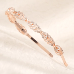Detail of rose gold crystal headband with floral patterns on white fur background