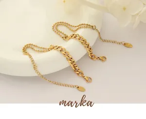 Close-up of 18k gold plated Cuban and beaded layering chains with K18 engraved tag