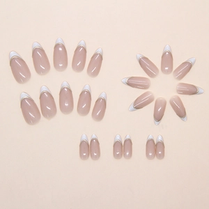 Close-up of almond-shaped French nails with white tips and elegant gold line details