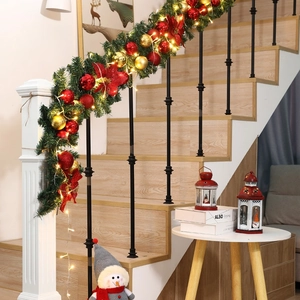 2.7m lighted Christmas garland with red flowers and ornaments on white staircase