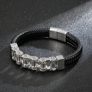 Close-up of industrial gear chain design on black braided leather stainless steel bracelet