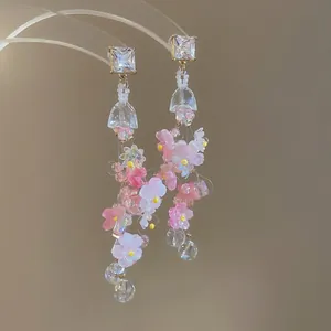 Pink and white resin flower tassel earrings with crystals and golden accents