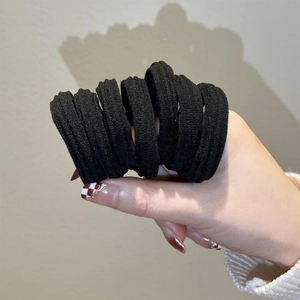 Close-up of high-elasticity black seamless hair ties showing stretch and thickness