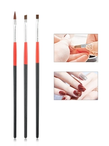 Close-up of three professional nail art brushes with red and black wood handles