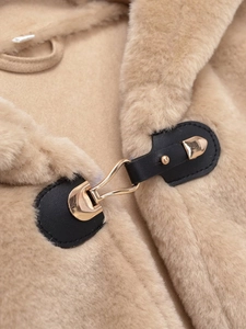 Detailed close-up of premium faux fur vest with black leather strap and gold metal buckle