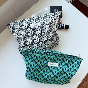 Detail view of cotton makeup bags with floral and geometric prints and zip closure