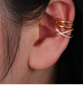 Détail macro de la bague d'oreille dorée avec lignes croisées et zircons micro-sertis
