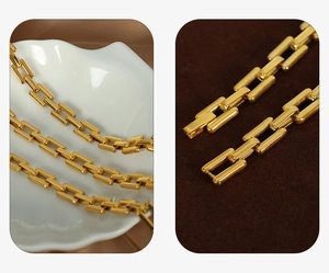 Close-up of golden rectangular link chain jewelry with precision buckle on brown velvet