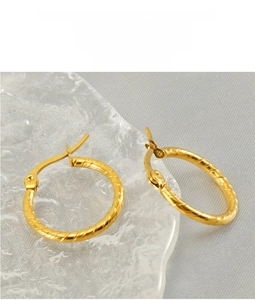 Detailed close-up of 18k gold-plated stainless steel hoop earrings with spiral twist texture