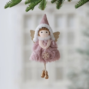Christmas plush angel ornament with pink dress and gold wings hanging on a pine branch