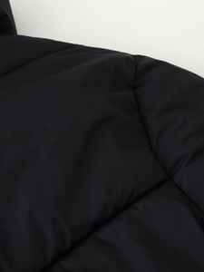 Detailed macro shot of black quilted fabric texture and stitching on winter cotton jacket