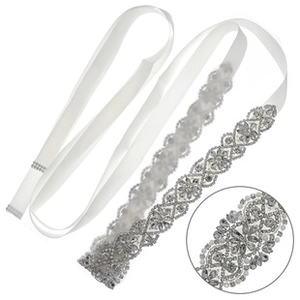Detail view of bridal sash featuring intricate silver floral rhinestones on white ribbon
