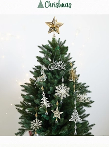Detailed view of gold star and silver Merry Christmas ornaments on a green tree