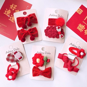 Detail of red festive hair clip set with velvet bows and knitted flowers on card