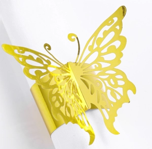 Detail of a hollow butterfly napkin ring in gold mirror finish on a white napkin