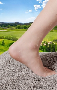Macro shot of plush absorbent bathroom mat showing soft texture under wet foot pressure