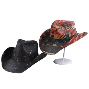 Detail of woven cowboy hats in black with gold spots and red-orange star prints