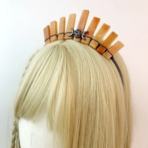 Detail of a handmade raw orange crystal crown with triple moon and star on blonde hair