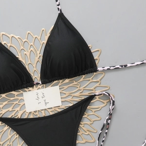 Detailed flat lay of black triangle bikini set with pink leopard print tie-side straps