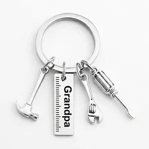 Detail view of silver metal keychain with mini hammer, wrench, screwdriver and Grandpa ruler