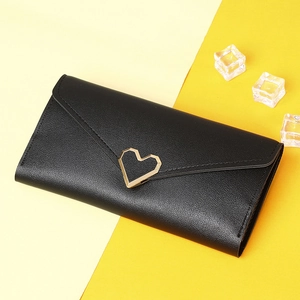 Detail of black long wallet with lychee leather texture and gold heart-shaped buckle