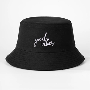 Detail of white good vibes script embroidery on classic black cotton bucket hat